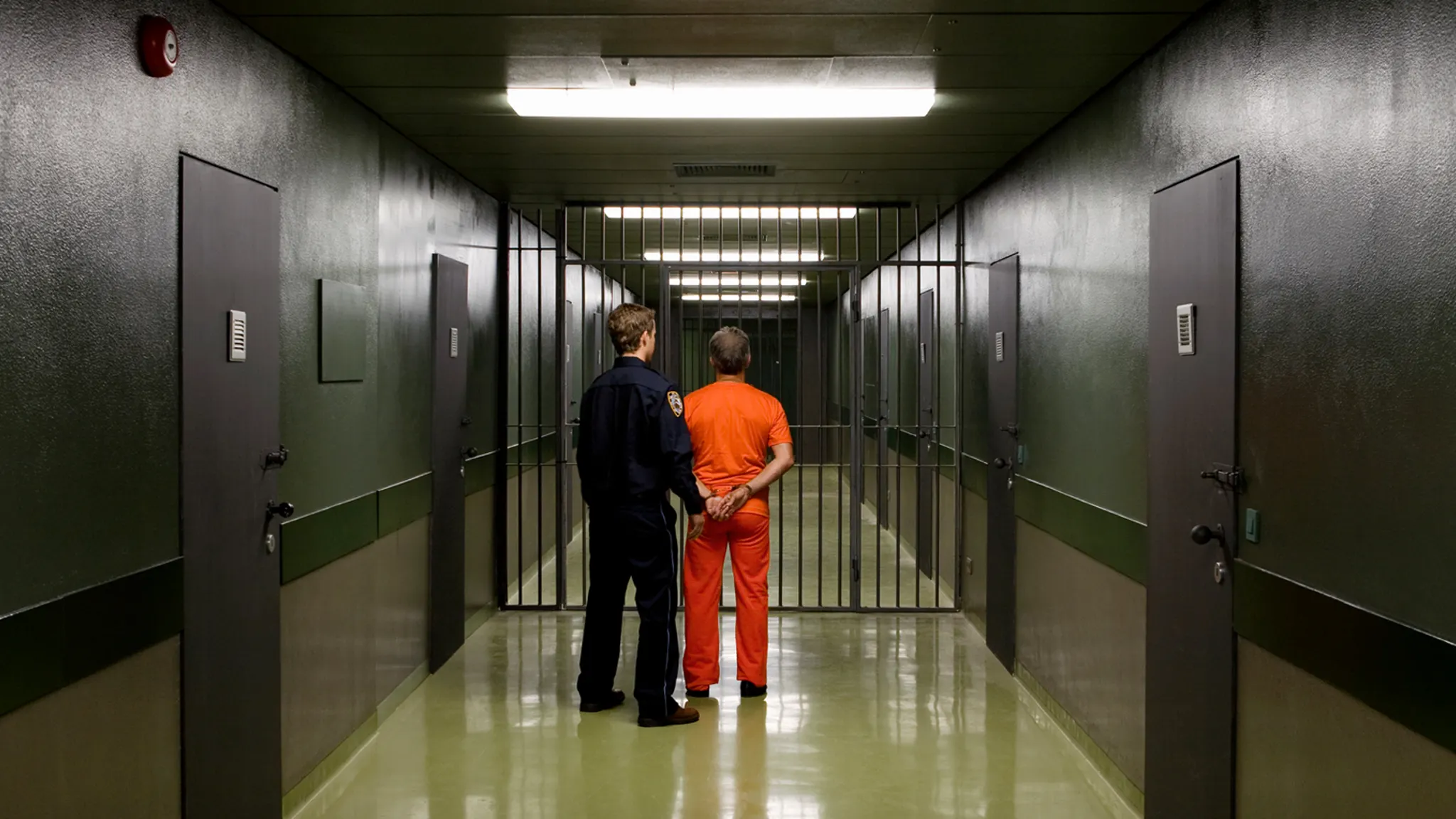 Correctional officer escorting inmate through hallway